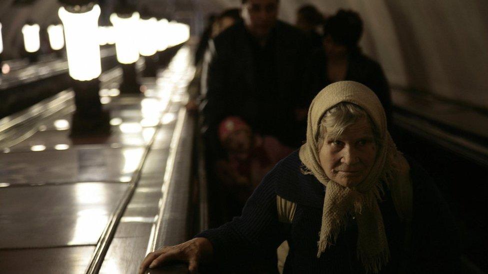 An elderly women rides an escalator in a Moscow metro station.