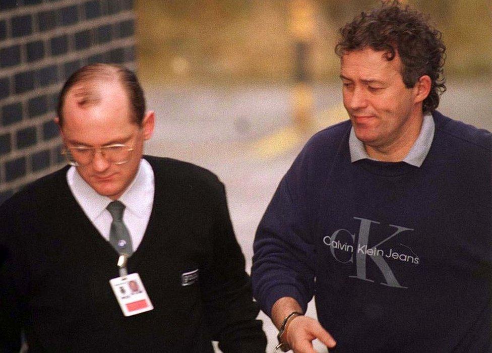 Barry Bennell, handcuffed to a custody officer, in 1998