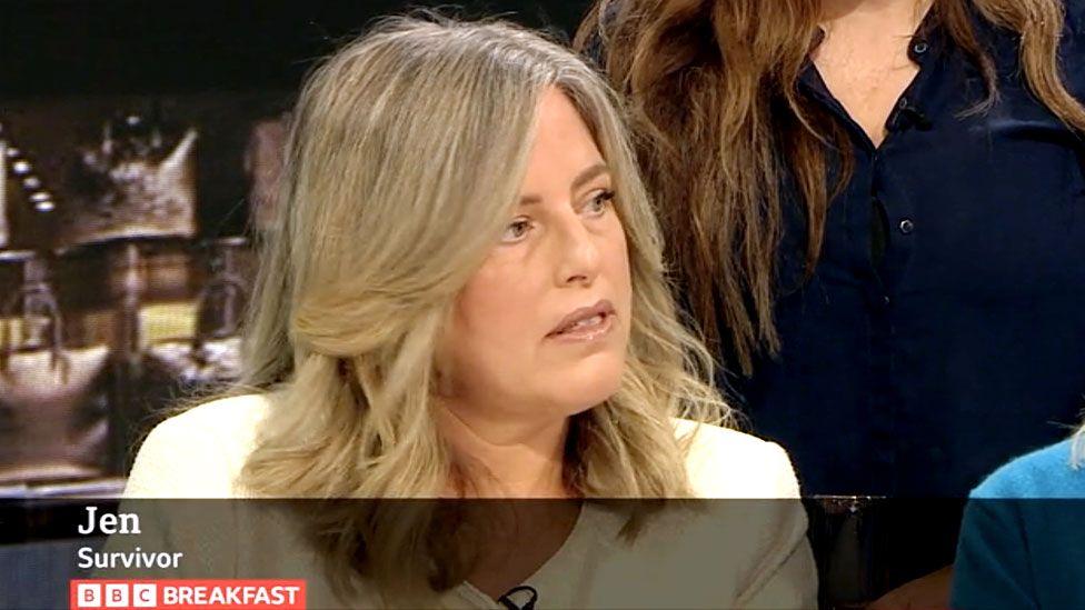 A screenshot of Jen speaking on BBC Breakfast in September. She's wearing a white jacket and is looking off-camera towards the hosts, with a serious expression on her face. The BBC Breakfast strapline describing her as "Jen, survivor" can be seen at the bottom of the screen