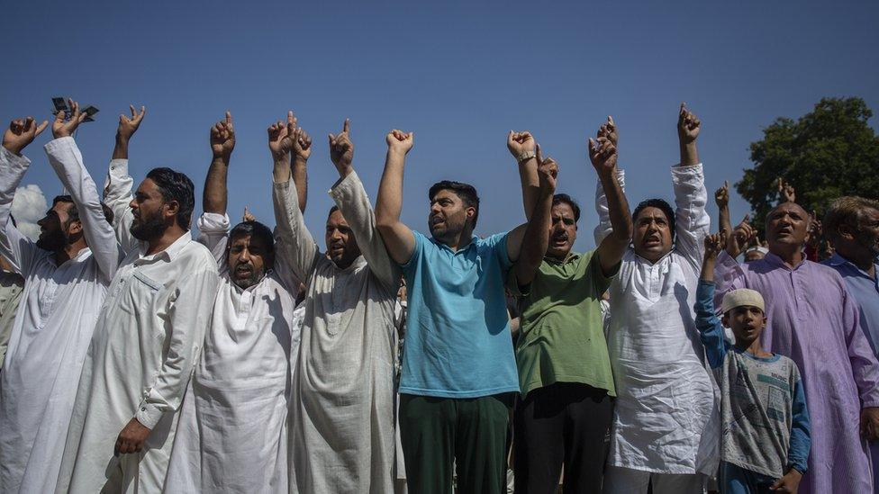 Men standing in a line at the protest