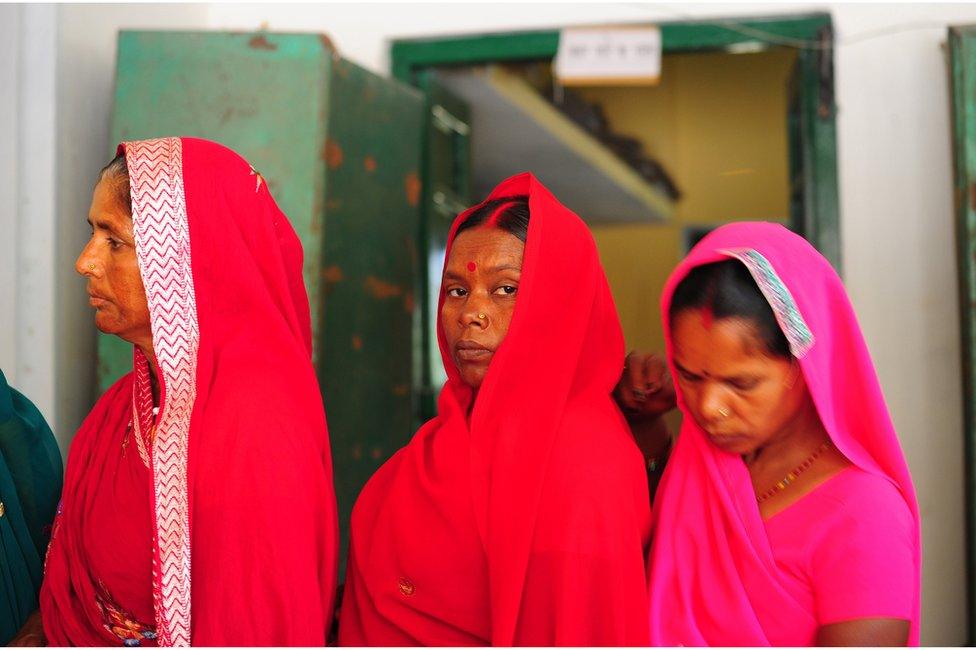 Indian women wait in a queue to cast their ballot at a polling station in Uttar Pradesh in 2014.