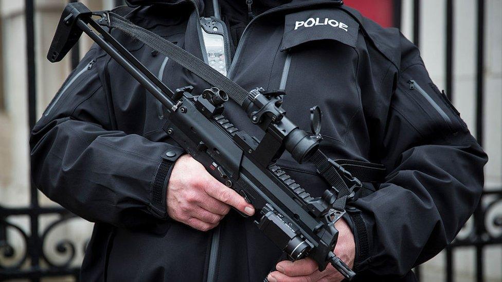 An armed police officer patrols on Whitehall