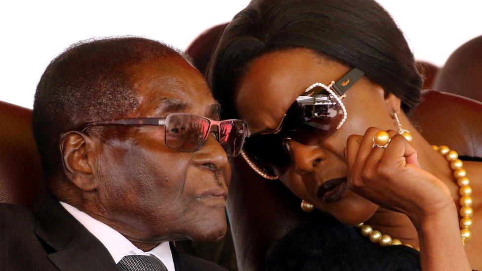 President Robert Mugabe (L) and his wife Grace are pictured speaking closely during a funeral they attended in August