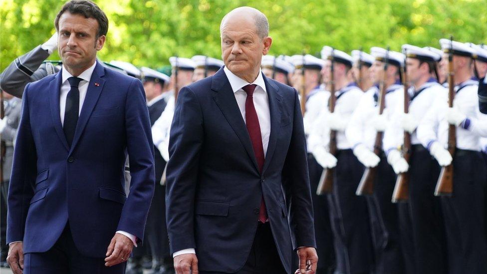 German Chancellor Olaf Scholz (R) and French President Emmanuel Macron walk during a reception with military honors at the Chancellery in Berlin, Germany, 09 May 2022