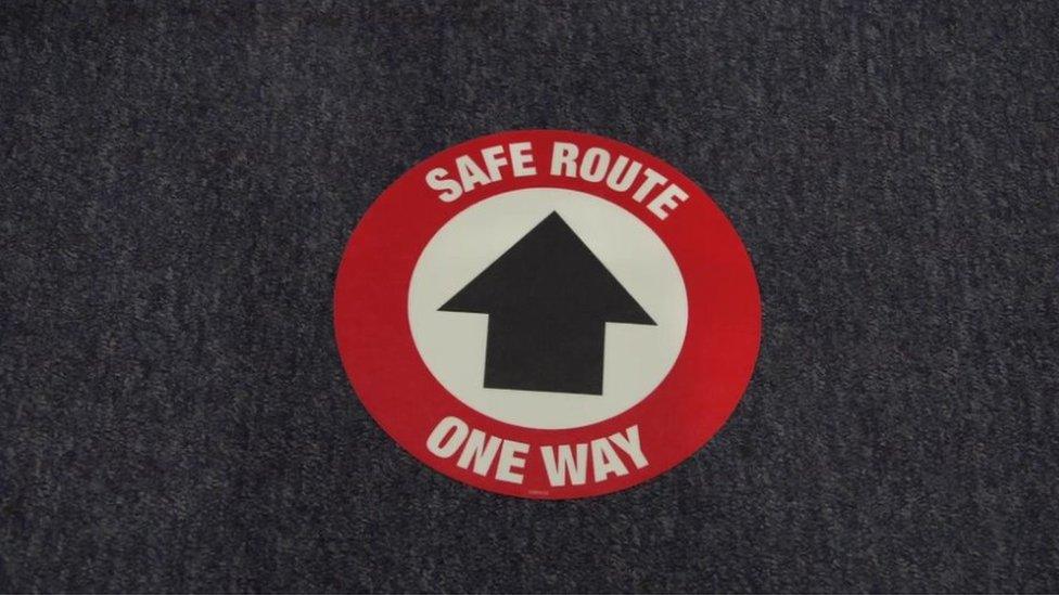 One way sign on corridor floor