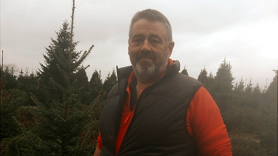 A man standing in front of trees