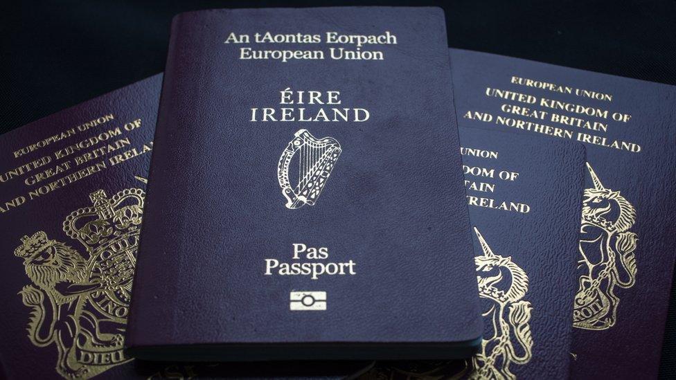 An Irish passport is seen on top of a pile of UK passports