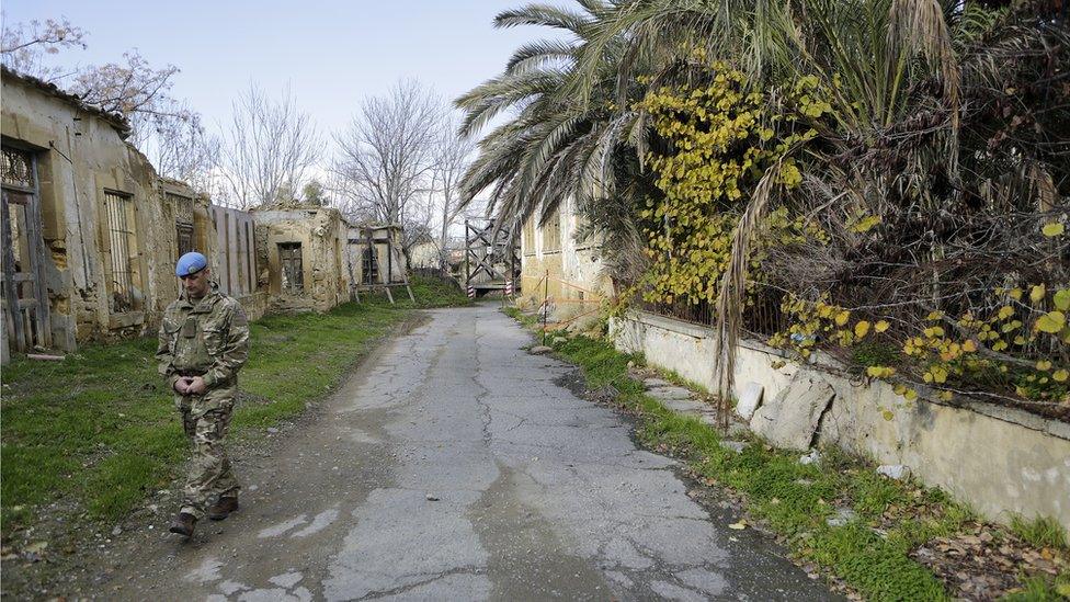 A UN soldier walks inside the UN buffer zone, Green Line, that divided the Greek, south, and Turkish, north, Cypriots controlled areas