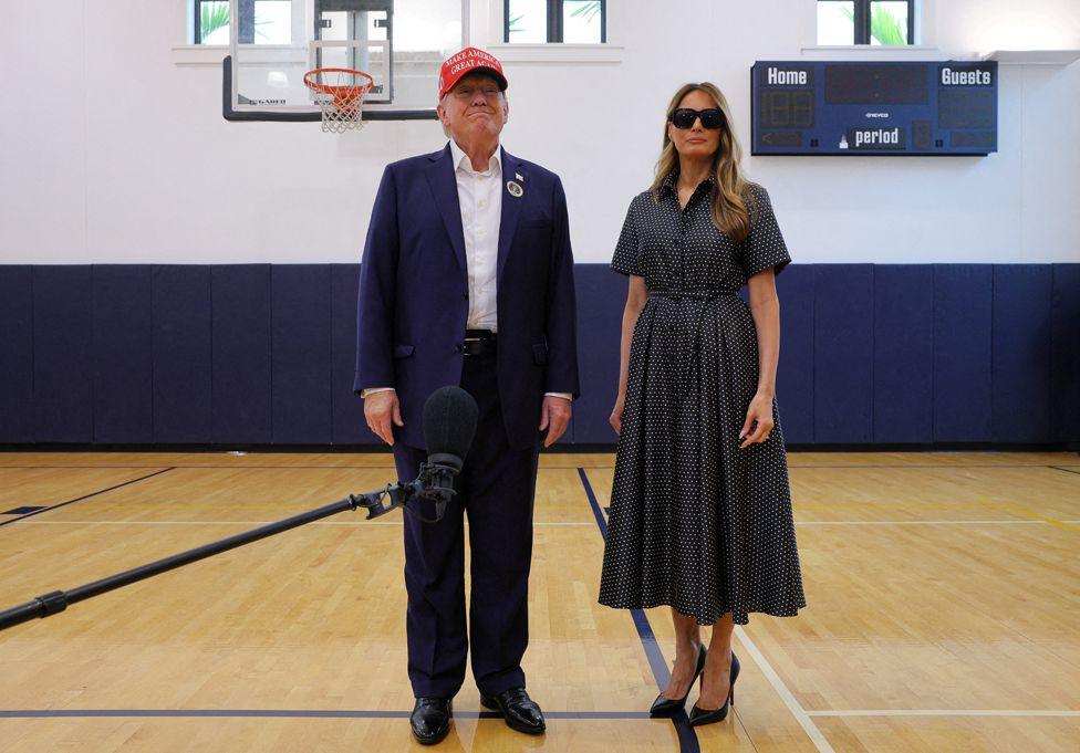 Republican presidential nominee and former U.S. President Donald Trump, accompanied by former U.S. first lady Melania Trump, speaks to reporters as he votes at Mandel Recreation Center on Election Day in Palm Beach, Florida, U.S., November 5, 2024