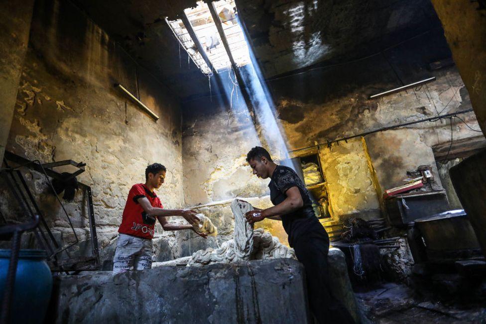 Men working at Salama's laundry  in Cairo, Egypt on 16 May 2024