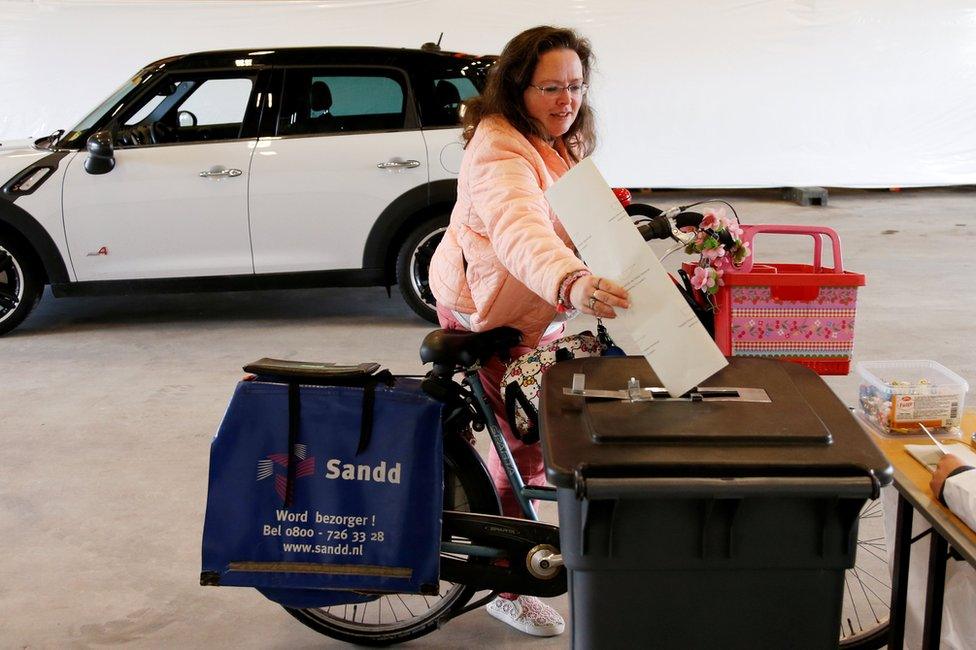 A cyclist casts a ballot in a drive-in polling station during the Dutch general election in Zuidplas, Netherlands, 15 March