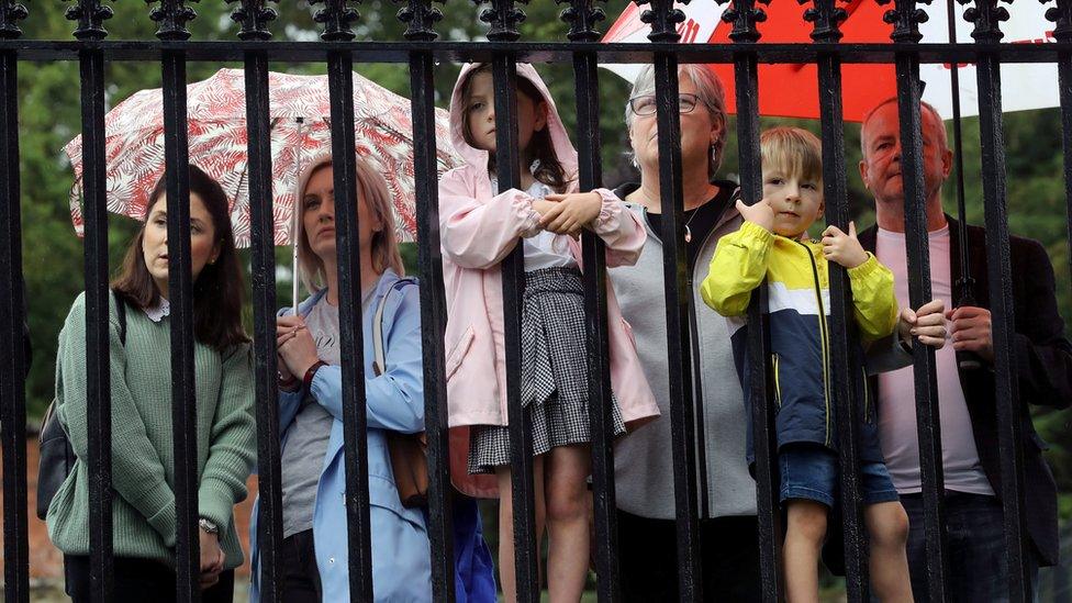 Local people watched from outside the gates of the cathedral.