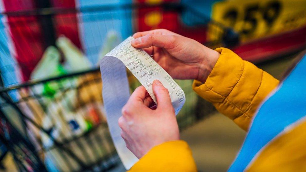 person checking a grocery receipt