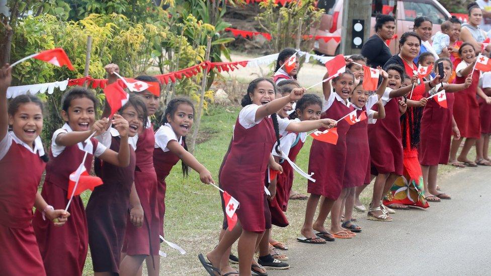 Schoolchildren greet Meghan and Harry