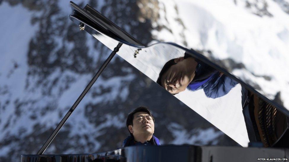 Lang Lang playing on a piano in the moutains