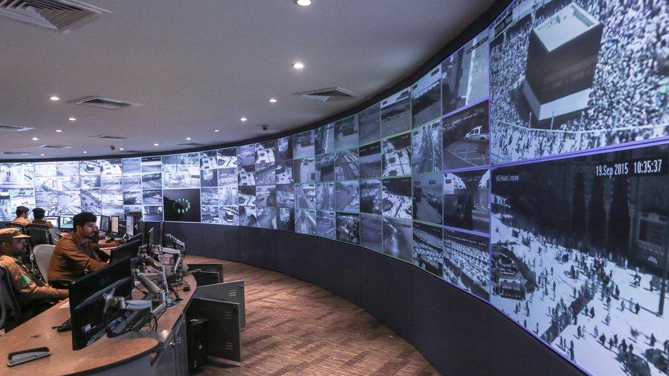 In this Saturday, Sept. 19, 2015 photo, Saudi security officers monitor live feed screens showing Muslim pilgrims in the holy city of Mecca, along with highways and high density areas, a few days before the annual pilgrimage, known as the hajj, in Mecca, Saudi Arabia