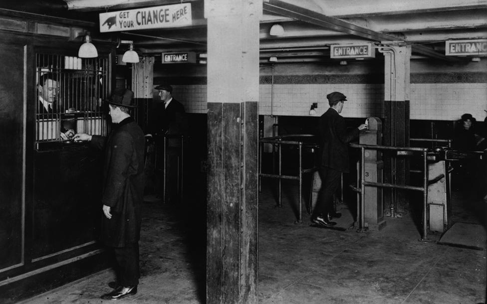 A man gets change to go through the ticket barrier on the New York Subway in the 1920s