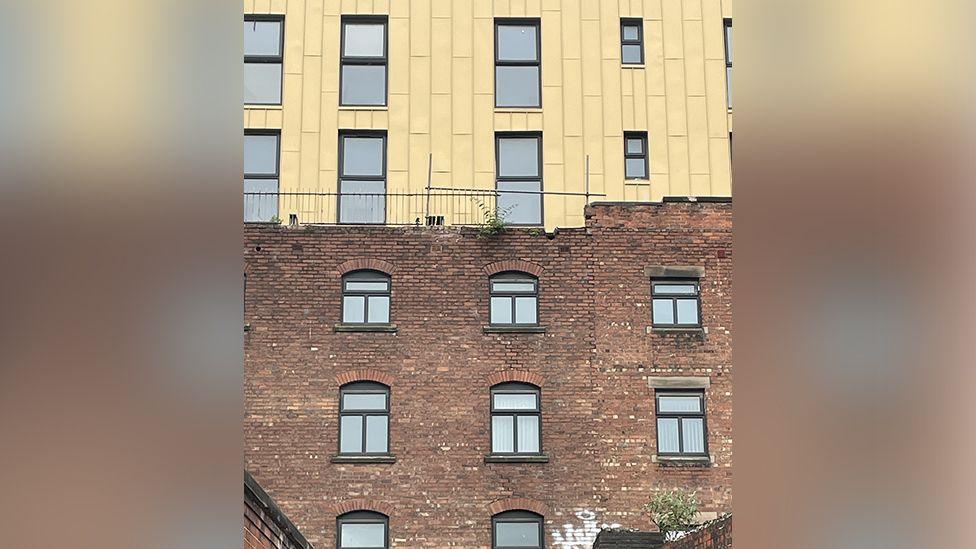 Rear view of the Glovers Court development showing exposed RSJs, cracks and missing coping.