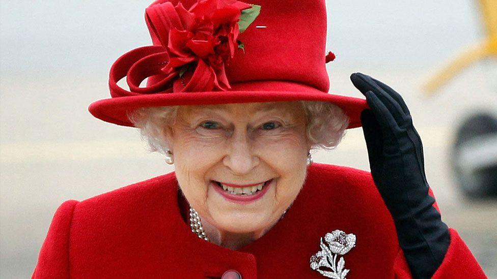 Queen Elizabeth II in a red dress and hat in 2011