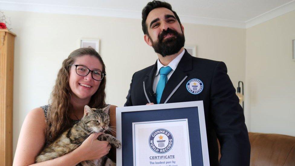 Guinness world record adjudicator Dave Wilson with Nicole Spink and her 14-year-old cat named Bella.