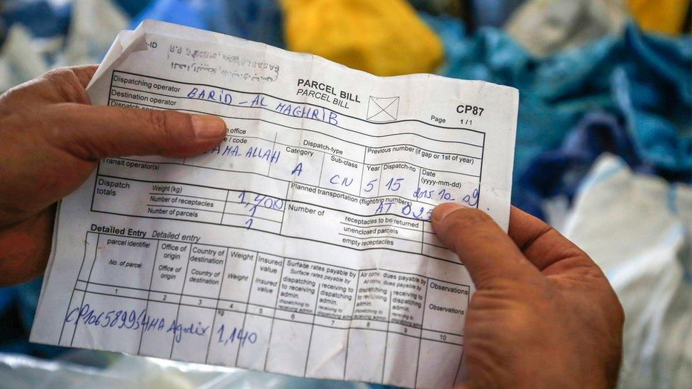 A Palestinian postal worker in Jericho holds a bill for a parcel dating back to 2015, 14 August 2018