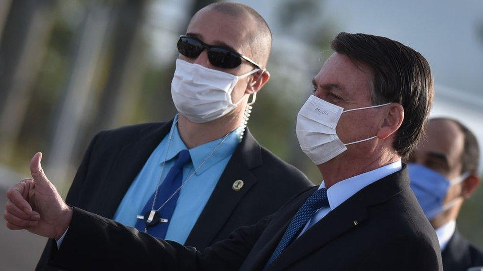 Wearing a protective face mask, Brazil's president Jair Bolsonaro arrives for the National Flag Raising ceremony in front of Alvorada Palace amid the Coronavirus (COVID-19) pandemic, in Brasilia, Brazil, on Tuesday, June 9, 2020