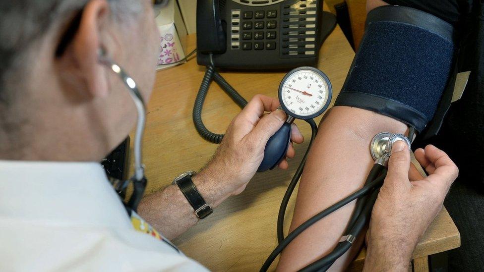 A doctor taking a patient's blood pressure