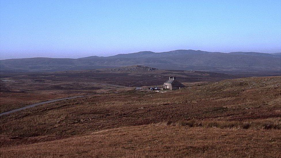 Cottage surrounded by moorland and hill