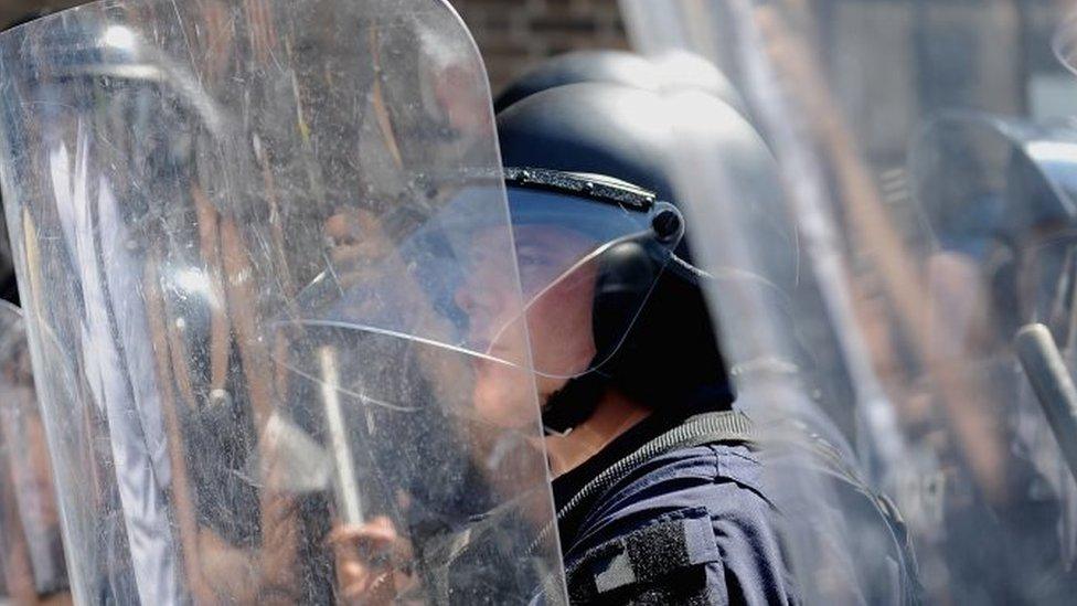 Police in riot gear stand by as protestors demonstrate following the not guilty verdict (15 September 2017)