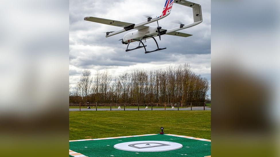 Drone in the air above a landing pad