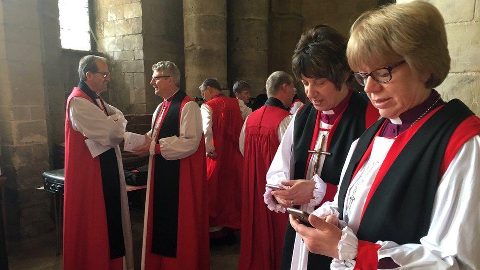 Bishop holding smartphones