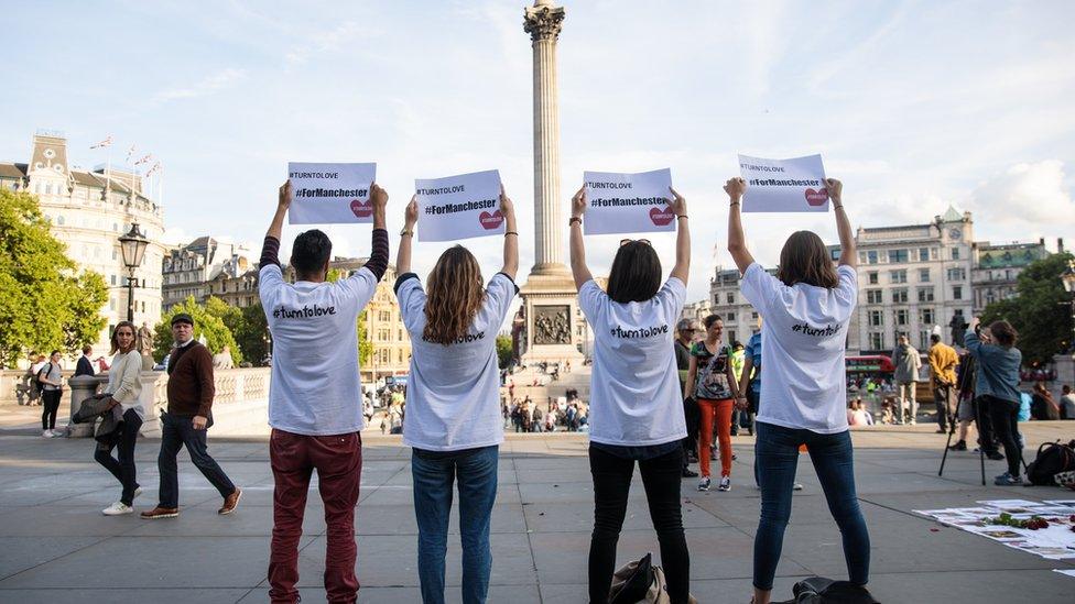 People hold up signs saying "Turn to Love for Manchester" during a vigil in Trafalgar Square, London