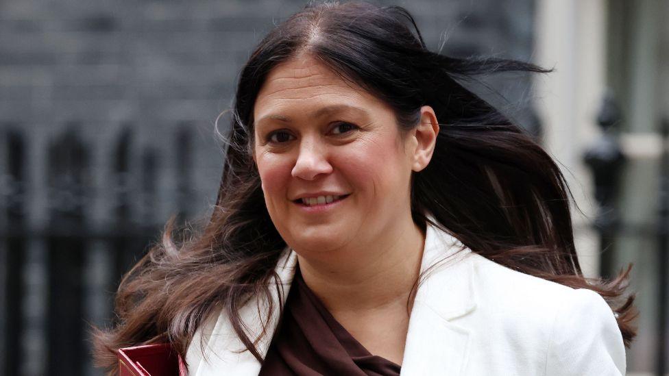 Lisa Nandy pictured outside Downing Street wearing a white jacket and carrying a red folder