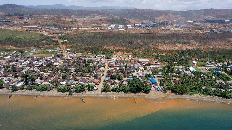 Red sediment pours from a river into the sea in the village of Kawasi in October 2022