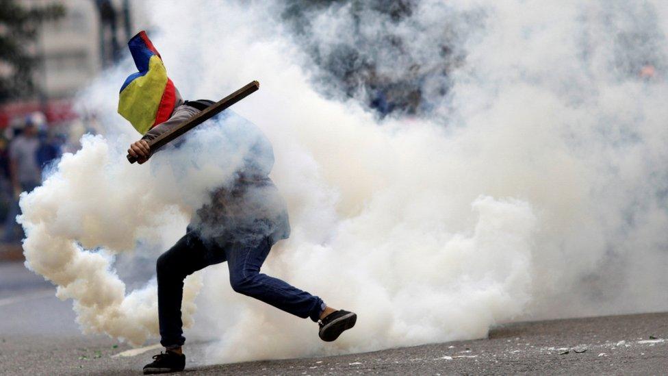 A demonstrator clashes with riot security forces during a rally against the Venezuelan government in July 2017