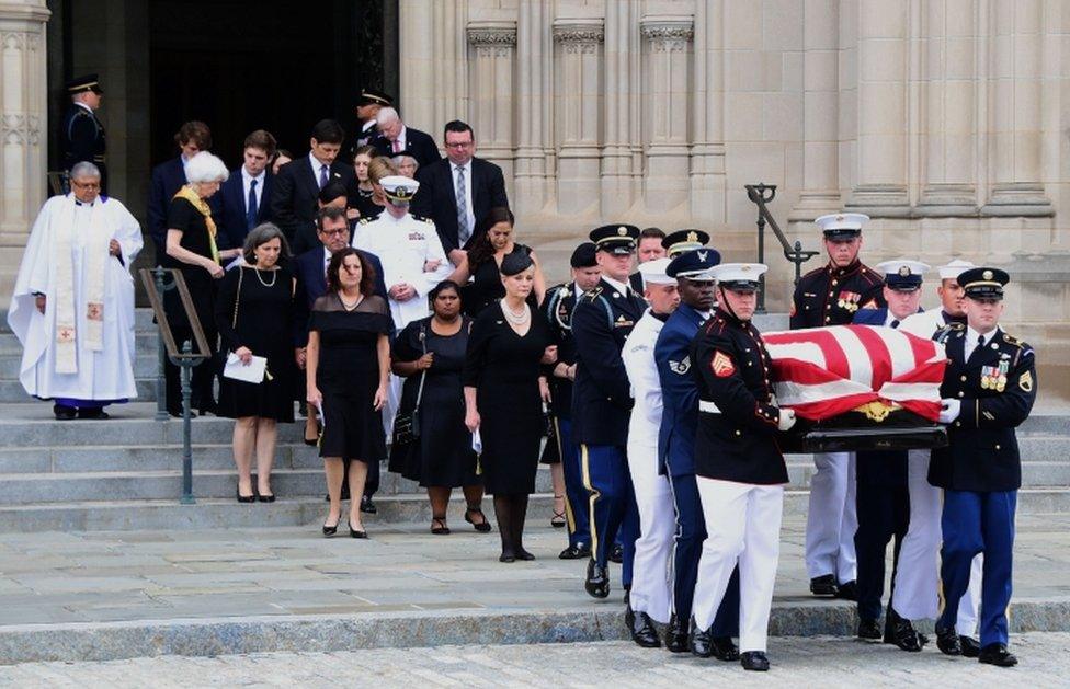 A military honour guard and the McCain family accompany the casket down the Cathedral steps