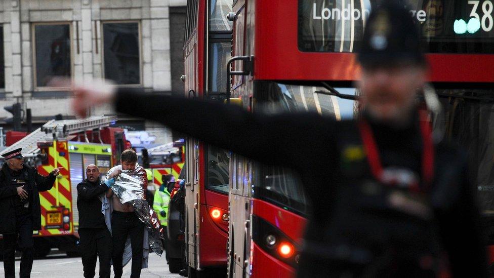 Police assist an injured man near London Bridge in London after an attack in November 2019