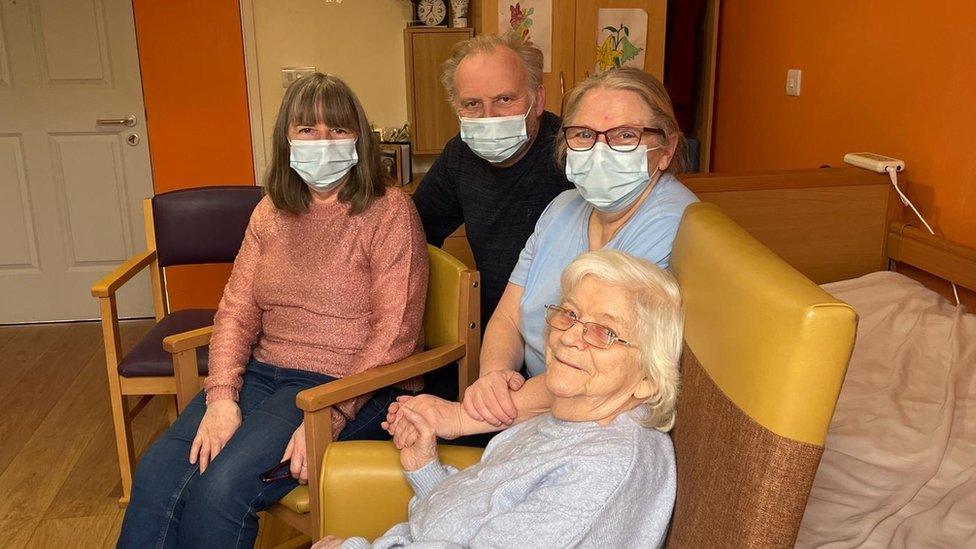 Mary surrounded by three members of her family in her care home