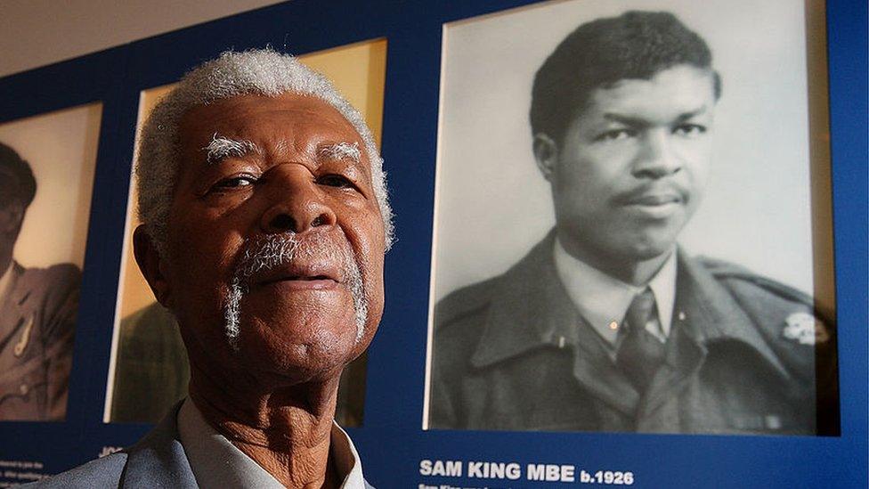 Sam King in 2008 next to a photo himself as a young man as part of an exhibition at the Imperial War Museum