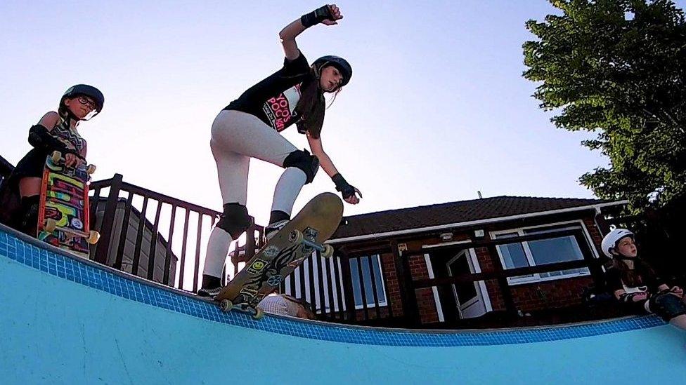 a-young-girl-on-a-skateboard-about-to-drop-into-a-bowl