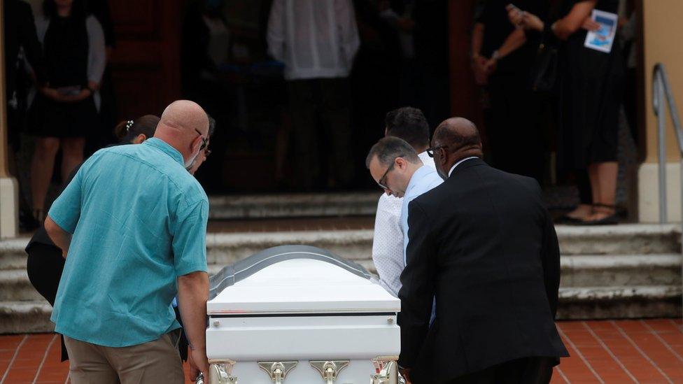 A coffin is carried into the church