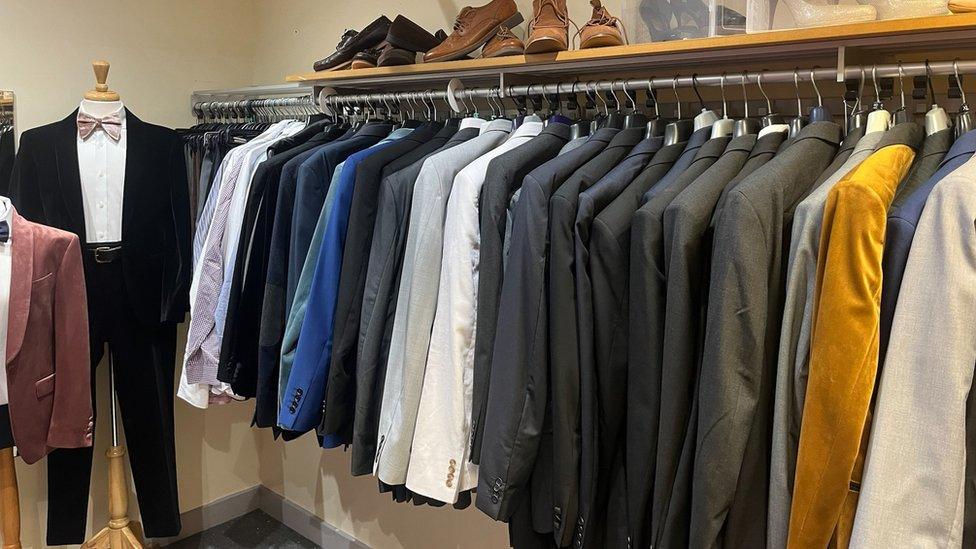 Prom suits in the shop lined up on a rack