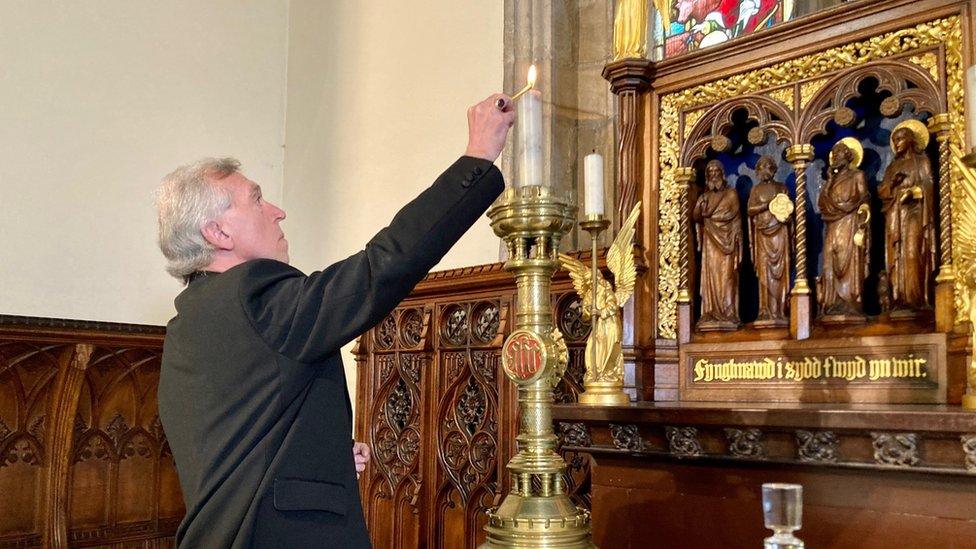 Archbishop Andrew John lighting a candle