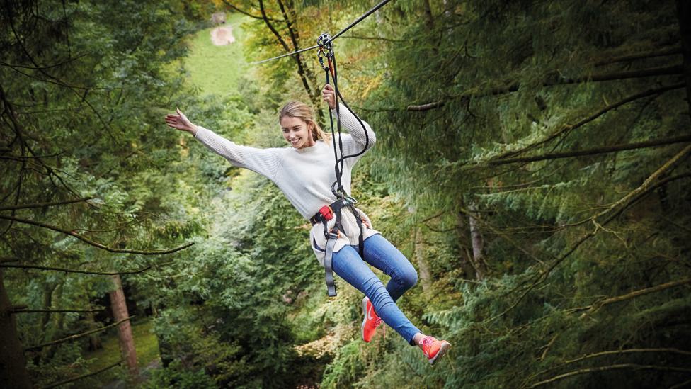 A woman in a Go Ape harness