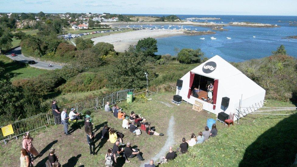 Small tent with small audience by the sea