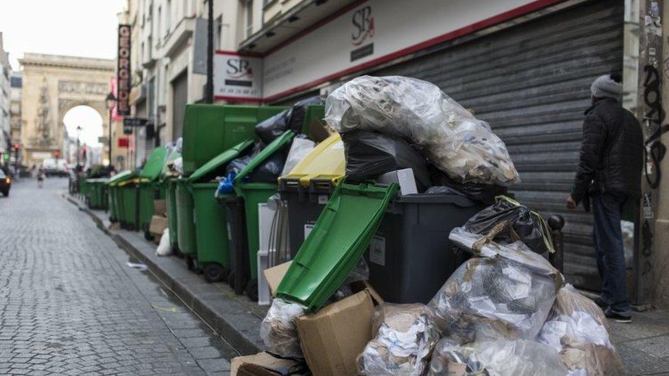 A man walks past a pile of rubbish bags in Paris (08 June 2016)