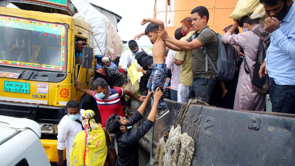 Man handing a young boy to another man at the ferry port