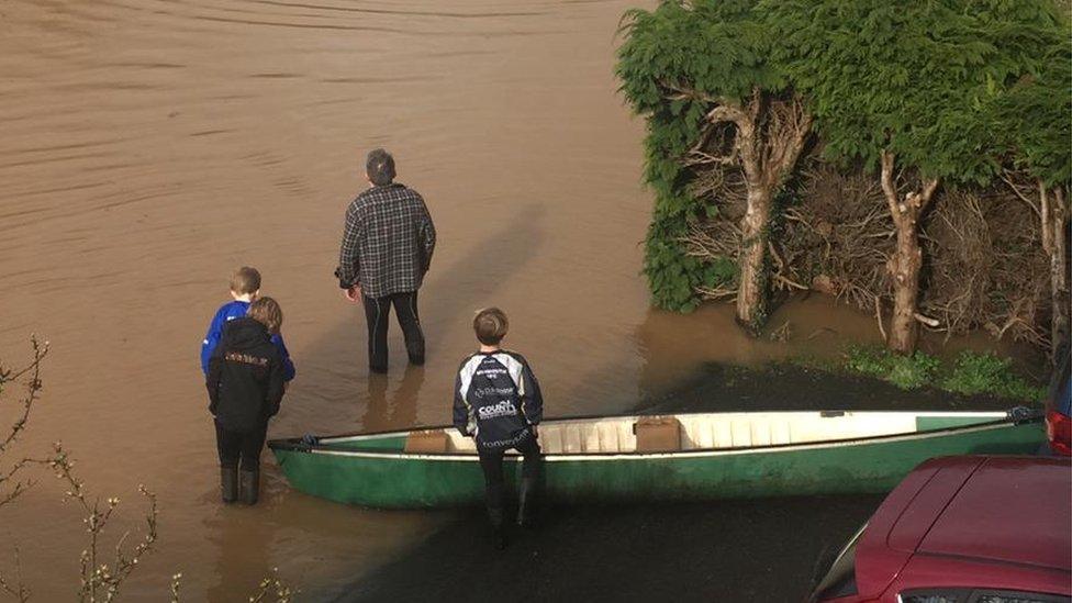 A family in Monmouthshire prepare a canoe on their driveway