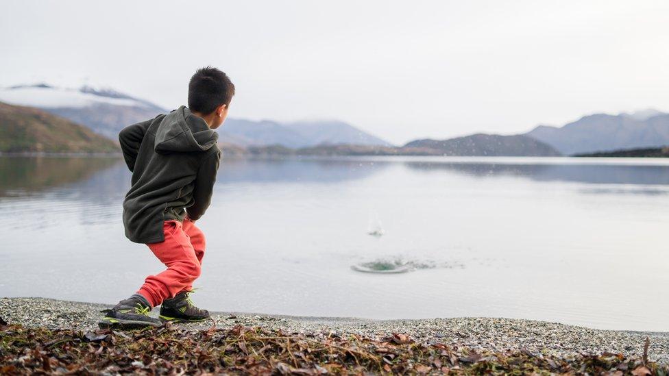 Boy skimming stones