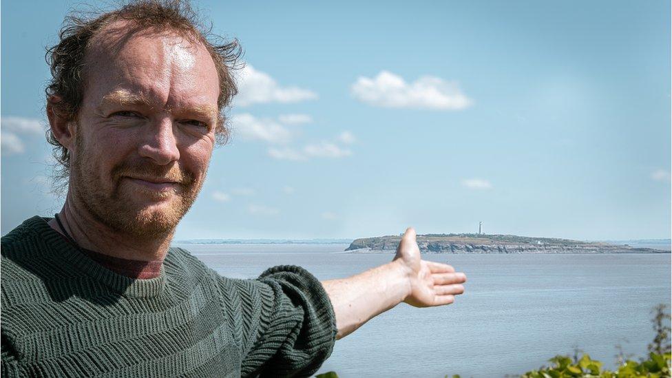 Simon Parker gesturing to an island